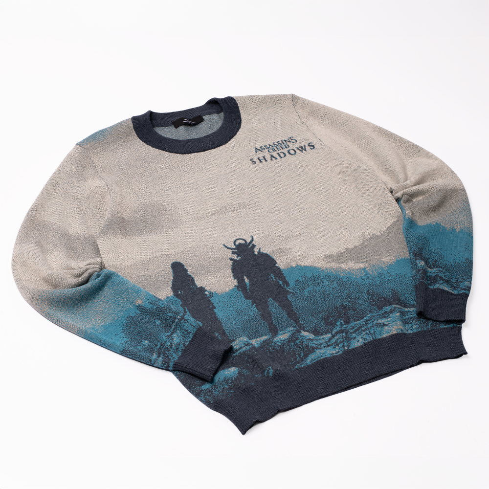 Knit sweater: Assassin's Creed Shadows title, plus two dark character silhouettes on a blue and gray landscape.