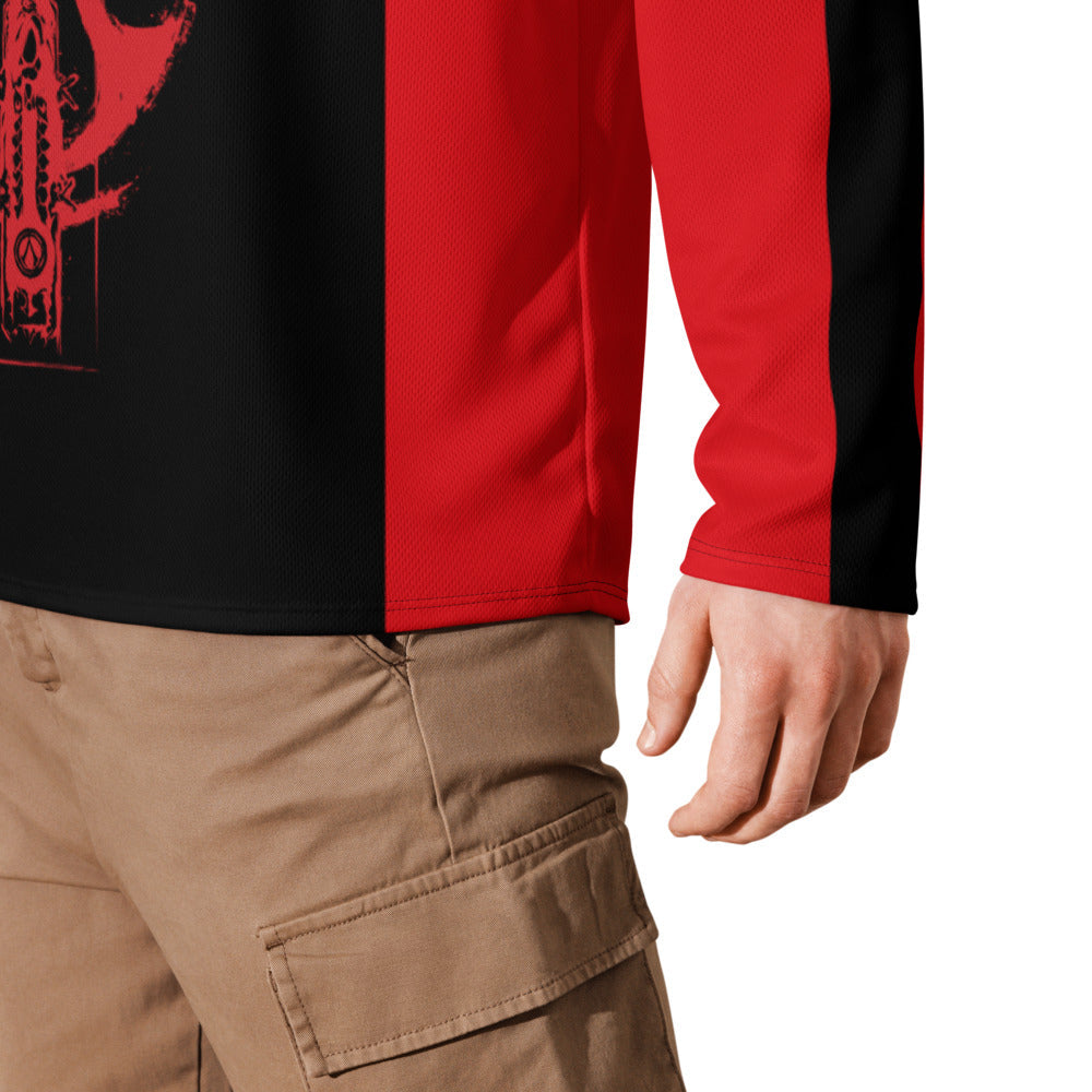 A person wears a black and red long-sleeve shirt with a red graphic, and khaki cargo pants. Shows lower torso and right hand.