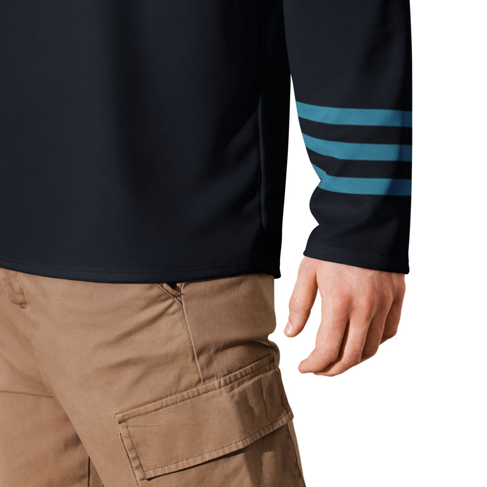 Dark blue mesh long-sleeve shirt featuring three horizontal teal stripes on sleeve; light brown cargo pants.