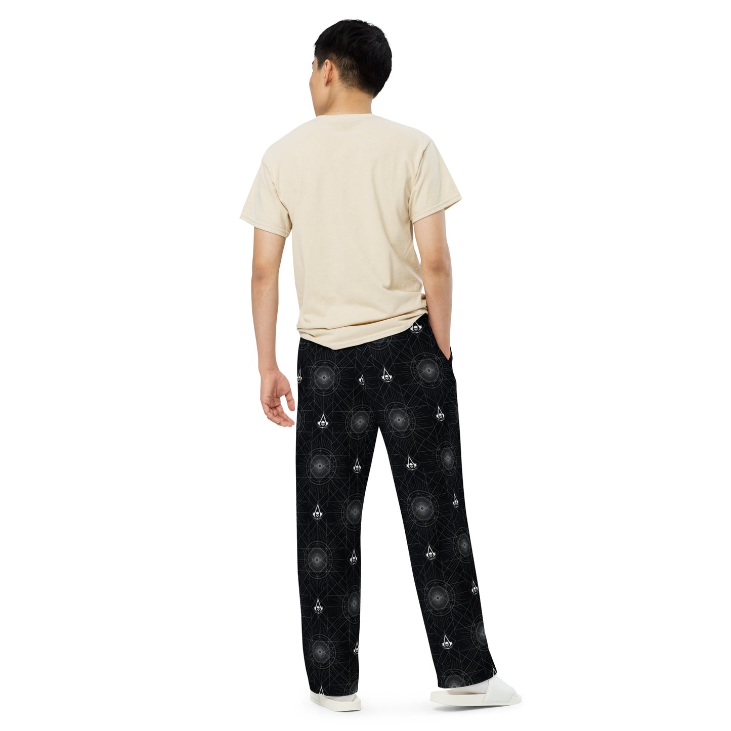 Black pants with white geometric circular patterns and Assassin's Creed skull logos.