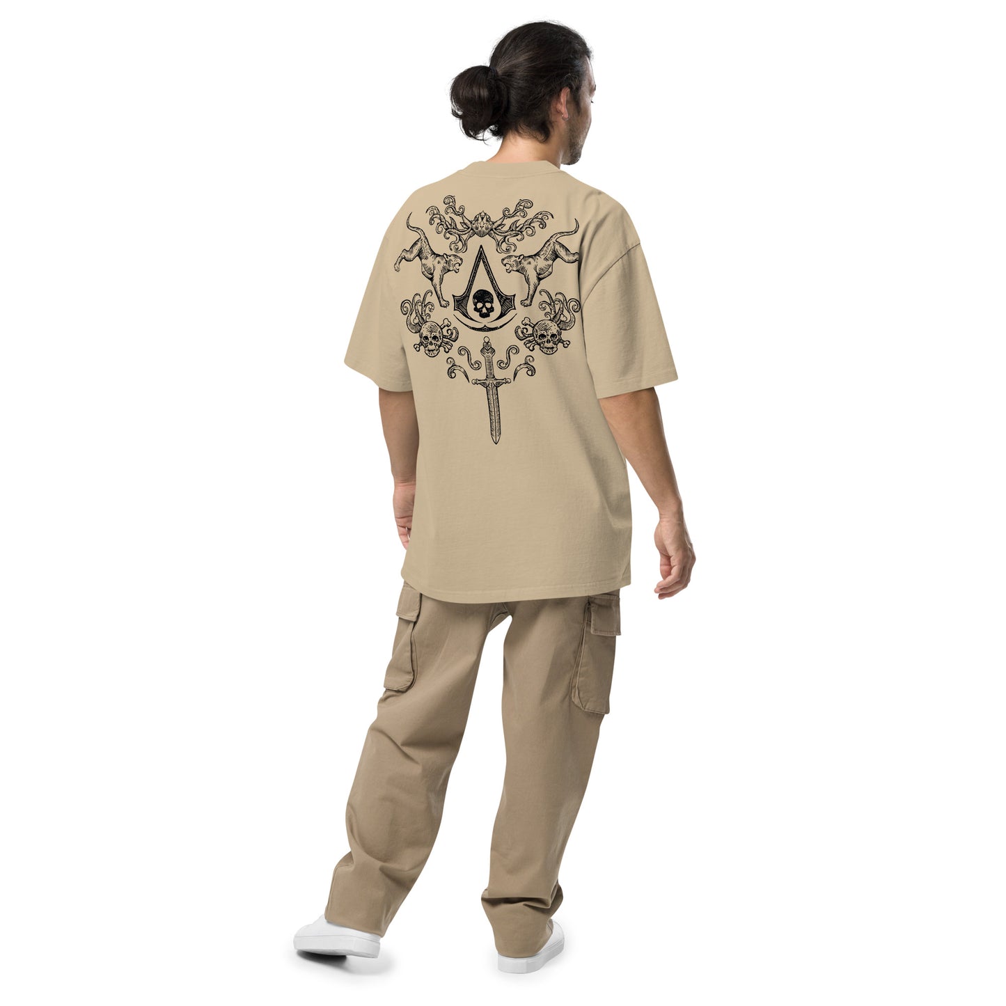 A person with a man bun, viewed from behind, wearing a beige t-shirt with a black skull, tiger, and sword design, and beige c
