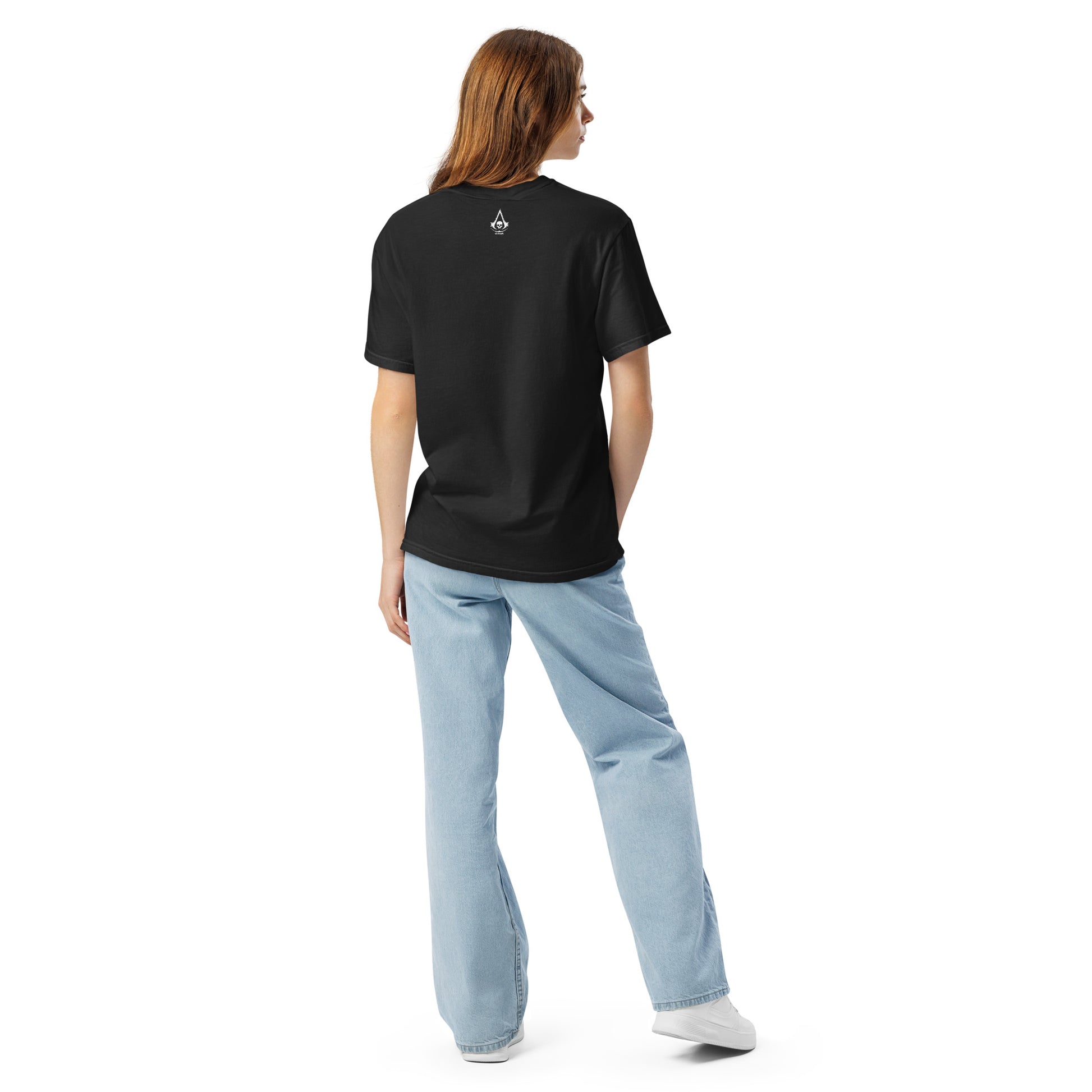 A woman from behind wearing a black t-shirt with a white skull logo, blue jeans, and white sneakers.